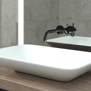 White bathroom sink with a contemporary lighted mirror, reflecting its classy environment.