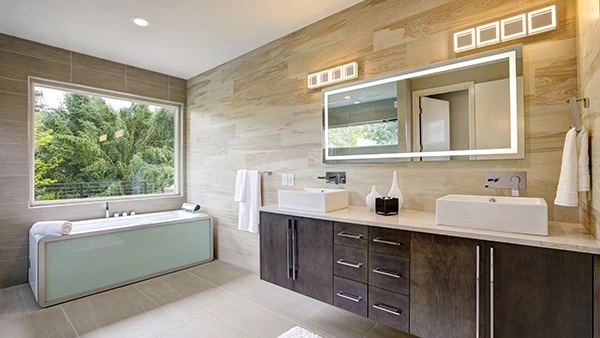 A compact of a wide glass window in a bathroom with an illuminated mirror above a double basin.