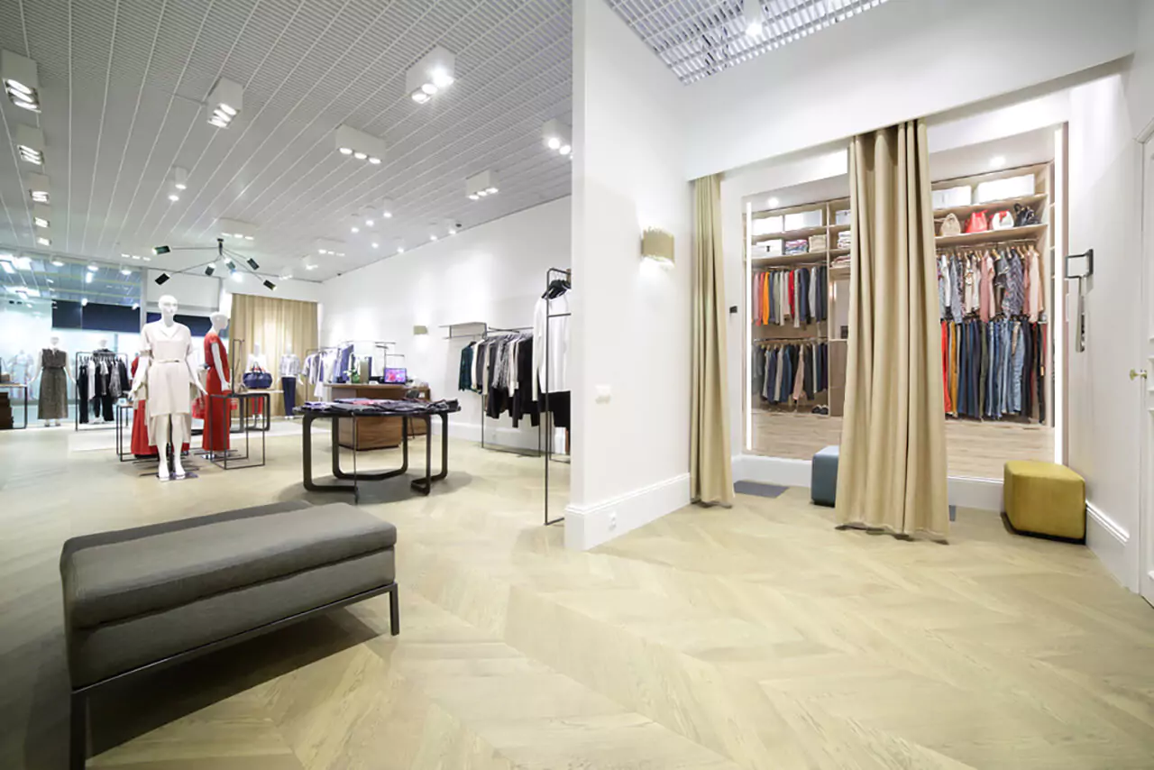 A luxurious clothing boutique with a stylish lighted mirror in its fitting room.