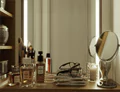 Tabletop mirror altogether with beauty kit in a wooden table in front of an LED mirror.